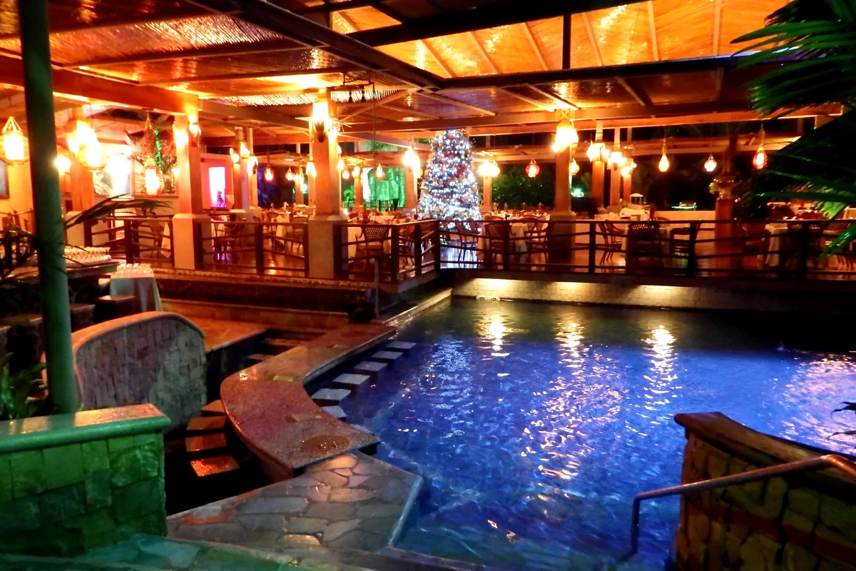 A La Fortuna hot springs pool lit up after dark (representative)